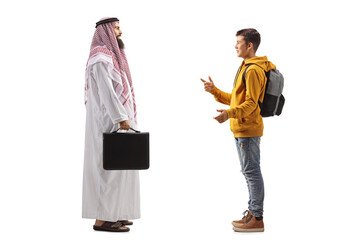 Full length profile shot of a saudi arab man in a thobe and a teenage male student having a conversation