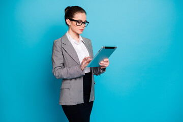 Naklejka na ściany i meble Portrait of attractive focused skilled lady specialist agent broker researching data cv using device isolated on bright blue color background