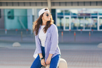 A young beautiful girl student leaves the airport in a new city, and waits for a taxi