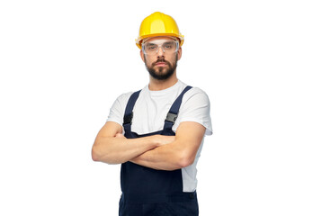 profession, construction and building - male worker or builder in yellow helmet and goggles with crossed arms over white background