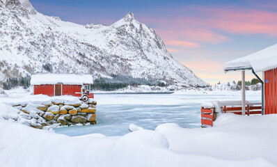 Wonderfull winter scenery with traditional Norwegian red wooden houses on the shore of Rolvsfjord on Vestvagoy island