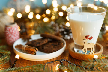 Milk and cookies prepared on wooden table for Santa coming home for Christmas 