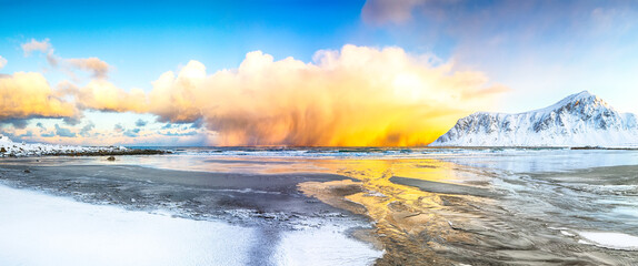 Incredible winter scenery on Skagsanden beach with illuminated clouds during sunrise.
