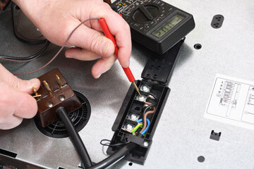 A professional electrician checks the connection quality, contact, voltage in the circuit of the...
