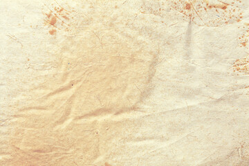 Texture of old vintage beige paper with coffee stain, crumpled background.