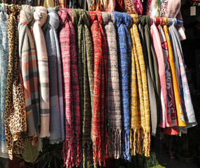 Fulares y pañuelos de colores brillantes para la venta en un mercadillo al aire libre - obrazy, fototapety, plakaty