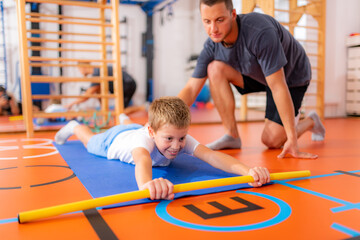 Back strengthening exercise for children with a bar