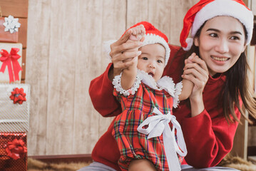 merry christmas and happy holidays. cheerful mom and her cute daughter girl and gifts. parent and little child having fun indoors. loving family with presents in room.