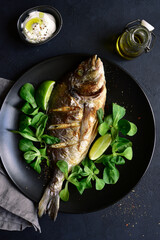 Grilled dorado or sea bream on a plate. Top view with copy space.
