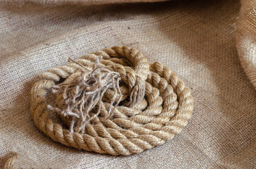 Thick natural rope wound in a reel on sackcloth.