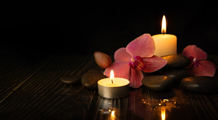 orchid flower with spa stones and candles. meditation and harmony concept