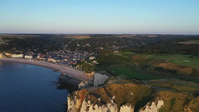 Vue aérienne du littoral normand, les falaises et la ville d'Étretat au coucher du soleil - Vidéo filmée par un drone
