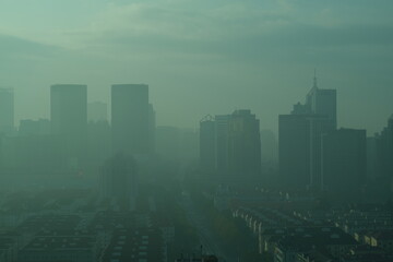 Fototapeta na wymiar high angle view of modern city buildings in air pollution in the morning