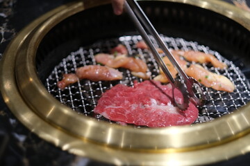 close up cooking raw meat on grill. Korean barbecue concept   