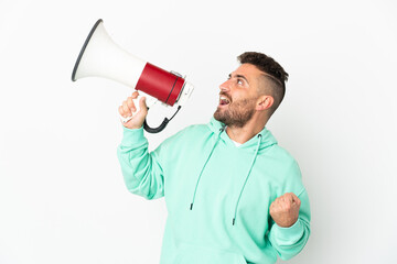 Caucasian man isolated on white background shouting through a megaphone to announce something in lateral position
