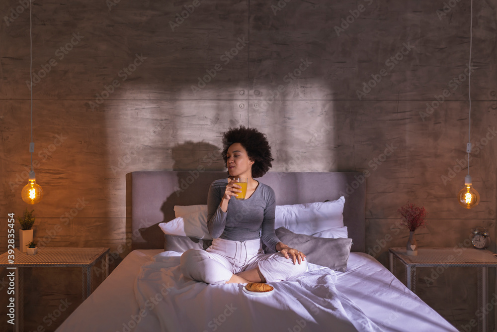 Wall mural woman eating breakfast in bed