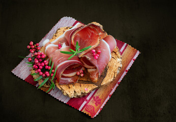 Slices of Alto Adige speck rolled with wild red pepper