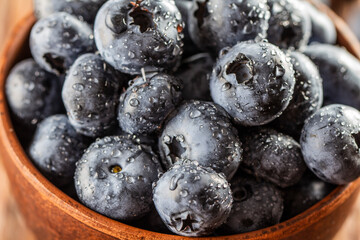freshly picked blueberries close up with water drops on wood background