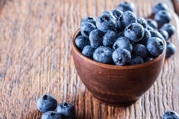 freshly picked blueberries close up with water drops on wood background