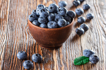 freshly picked blueberries close up with water drops on wood background