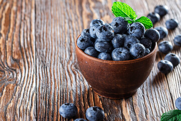 freshly picked blueberries close up with water drops on wood background