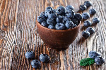 freshly picked blueberries close up with water drops on wood background