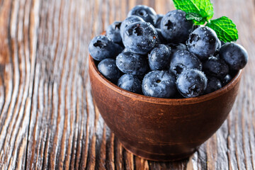 freshly picked blueberries close up with water drops on wood background
