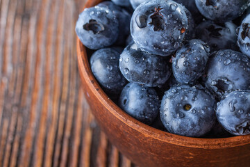 freshly picked blueberries close up with water drops on wood background