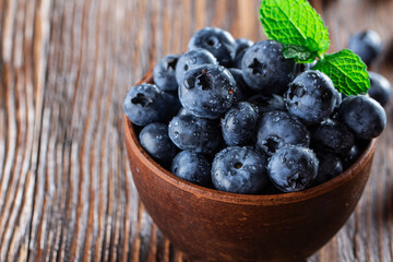 freshly picked blueberries close up with water drops on wood background
