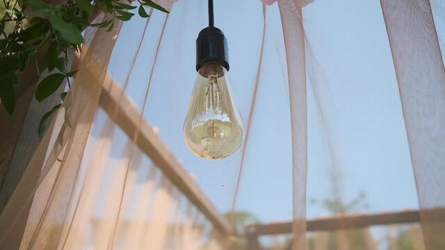 Lamp. Wedding decor. Beautiful wedding arch with fresh flowers in the garden on a summer sunny beautiful wedding day