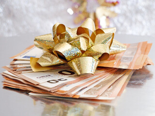 stack of money with bow rotation on silver xmas background, merry christmas, happy new year, wealth...