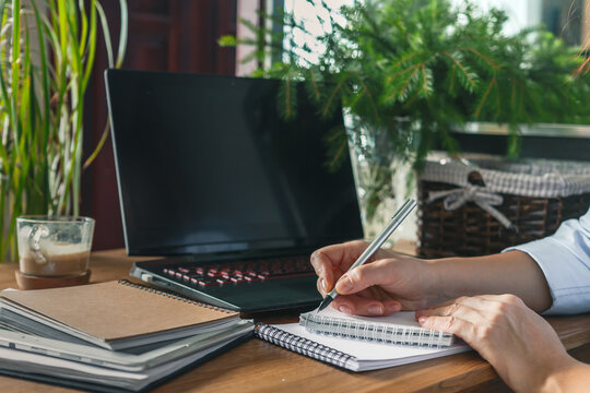 2021 Goals Planning A Wishlist In A Crisis, A Woman Quarantined And Working, Planning Goals At Home, Lockdown Covid19. Business Woman Holding A Pen And Notebook For Planning, Goals