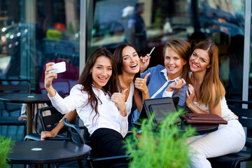 Four women sitting in a cafe on the street