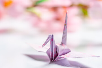 白い玉砂利の上の和柄の折り鶴と桜の花