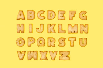 Letras de galletas abecedario sobre un fondo amarillo. Vista superior