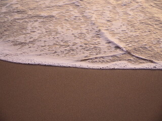 Clean ocean on sand, close-up environmental image; background
