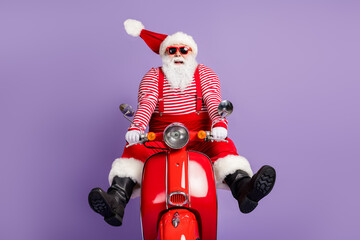 Photo of funky santa claus carefree drive scooter wear x-mas costume striped shirt cap eyewear isolated purple color background