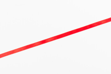 Top view of Red ribbon isolated shiny rolled on white background. Flat lay view.