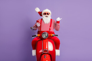 Photo of santa drive bike hold phone direct finger empty space wear x-mas costume cap sunglass...