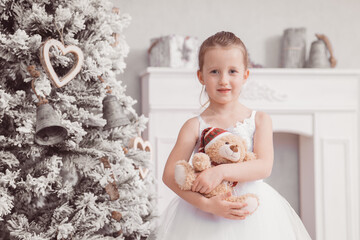 Weihnachten hübsches Mädchen im weißem Kleid mit Teddy vor Weihnachtskulisse Xmas Prinzessin...