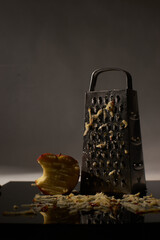 grater with partly sliced apple dark theme