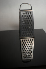 grater reflected on black ground 