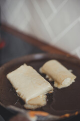 The process of making breakfast: a tortilla with cheese is fried in a pan.