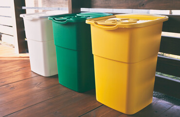 Three colorful trash cans for sorting garbage. For plastic, glass and paper