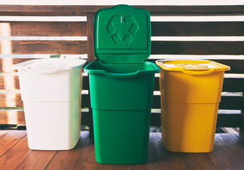 Three colorful trash cans for sorting garbage. For plastic, glass and paper