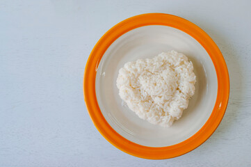 Heart shaped rice in a plate on a white background