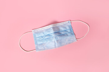 Protective medical face mask on rose background