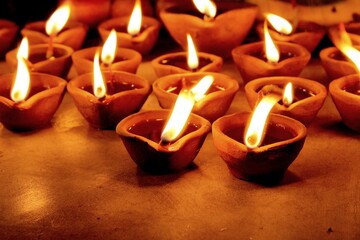 Flickering earthen lamps with lights on Deepawali