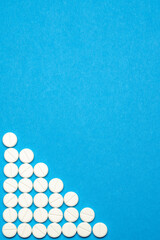 group of round white pills on blue background