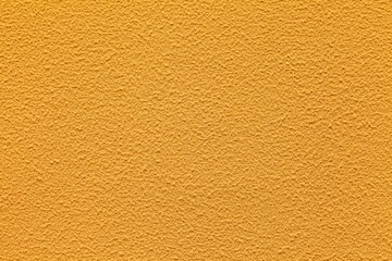 The walls of the cement building are painted in yellow with rough patterns background seamless and texture